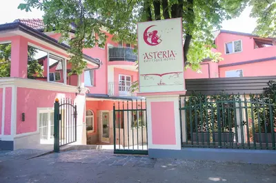 a pink building with a sign in front of it at Boutique Hotel Asteria in Ljubljana