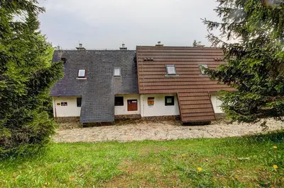 a house with two roofs and a yard at Apartma David Rogla in Zreče