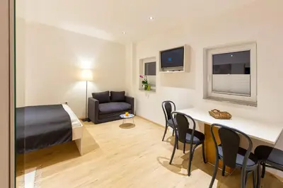 a bedroom with a bed and a table and chairs at Apartments SHISHKA in Ljubljana