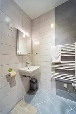 a white bathroom with a sink and a mirror at Apartments SHISHKA in Ljubljana