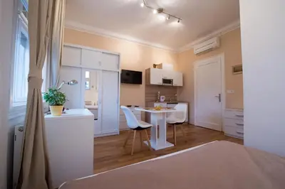 a living room with a table and a kitchen at B&B Vila Teslova in Ljubljana