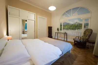 a bedroom with two beds and a painting on the wall at B&B Vila Teslova in Ljubljana