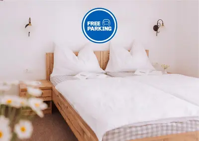 two beds in a bedroom with a free parking sign at Gostišče Krivograd in Prevalje