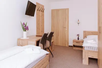 a room with two beds and a desk with a computer at Gostišče Krivograd in Prevalje