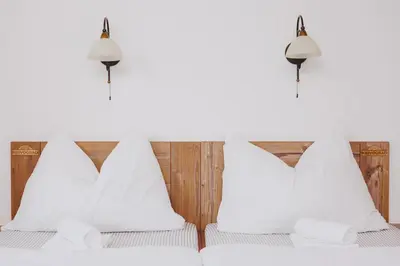 a white bed with white pillows on top of it at Gostišče Krivograd in Prevalje