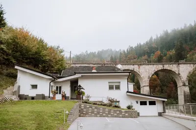 a white house with an archway in the background at Gostišče Krivograd in Prevalje
