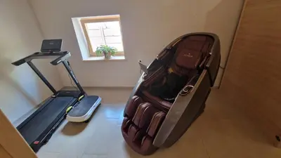an open suitcase sitting on the floor next to a treadmill at Tourist farm Gričnik in Resnik