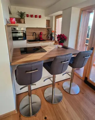 a kitchen with a counter and two bar stools at Tourist farm Gričnik in Resnik