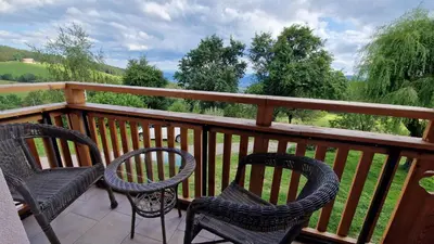 three chairs sitting on a balcony with a view at Tourist farm Gričnik in Resnik