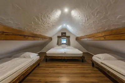 a attic room with two beds and a window at Apartment Trentar in Kranjska Gora