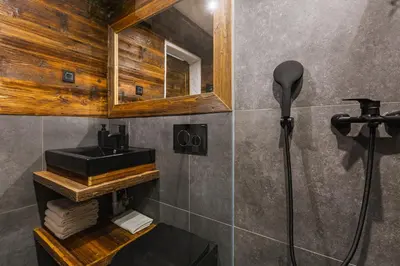 a bathroom with a shower and a black sink at Apartment Trentar in Kranjska Gora