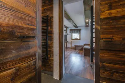 a hallway with wooden doors and a living room at Apartment Trentar in Kranjska Gora