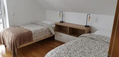 a bedroom with two beds and a table with lamps at 7th Mill apartments in Kranj