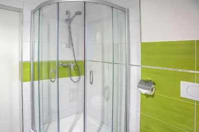 a shower with a glass door in a bathroom at 7th Mill apartments in Kranj