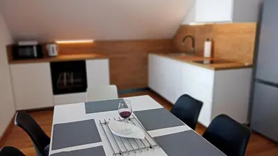 a dining room table with a glass of wine on it at 7th Mill apartments in Kranj
