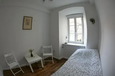 a white bedroom with a bed and a window at 3 Bridges App in Ljubljana