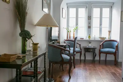 a living room with chairs and a desk and windows at 3 Bridges App in Ljubljana