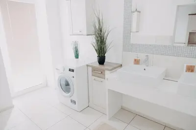 a white bathroom with a washing machine and a sink at Apartments Miki's in Bled