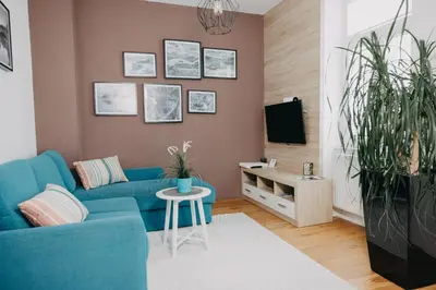 a living room with a blue couch and a tv at Apartments Miki's in Bled