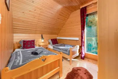 a bedroom with two beds in a log cabin at Chalet Trzinka - Triglav National Park in Goreljek