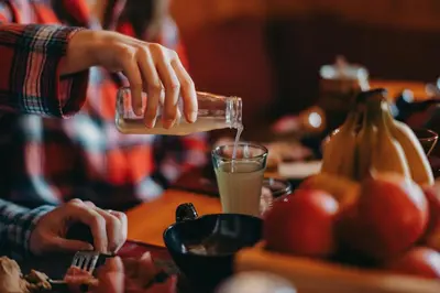 a person pouring a glass of orange juice at Chalet Trzinka - Triglav National Park in Goreljek