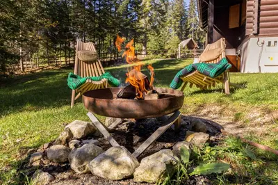 a fire pit in a yard with two chairs at Chalet Trzinka - Triglav National Park in Goreljek