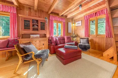 a living room with a red couch and a chair at Chalet Trzinka - Triglav National Park in Goreljek