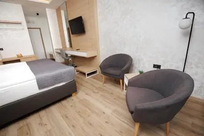 a bedroom with a bed and two chairs and a desk at Gostilna Müller in Črnomelj