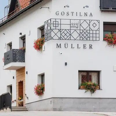 a white building with a sign for a miller at Gostilna Müller in Črnomelj
