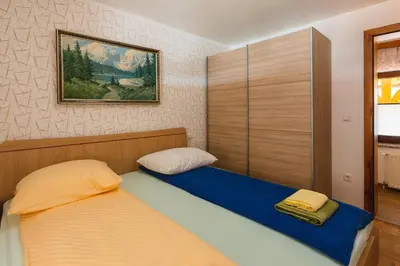 a bedroom with two beds and a painting on the wall at Apartment Ledrar in Bled