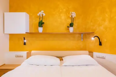 a bedroom with a bed and two plants on a wall at Apartment Ledrar in Bled
