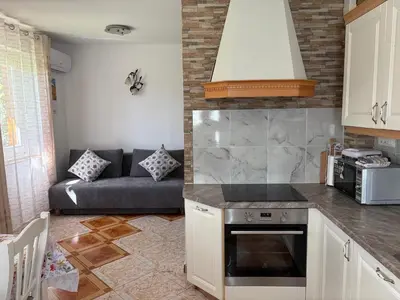 a kitchen and a living room with a couch at Apartments Nina in Bled