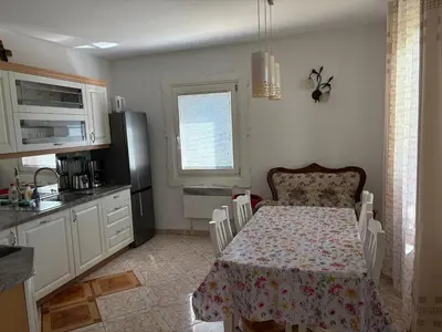 a kitchen with a table and a kitchen with a table and a kitchen at Apartments Nina in Bled