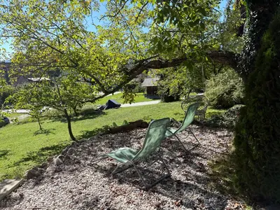 two green chairs sitting under a tree in a yard at Apartments Nina in Bled