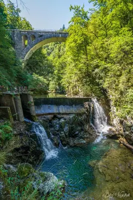 a bridge over a river with a waterfall at Apartments Nina in Bled
