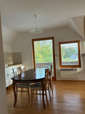 a kitchen and dining room with a table and chairs at Apartments Nina in Bled