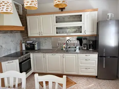 a kitchen with white cabinets and a stainless steel refrigerator at Apartments Nina in Bled