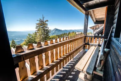 a bench on the side of a building with a view at Apartments Zvoh, Krvavec, Ski-in, Ski-out in Cerklje na Gorenjskem