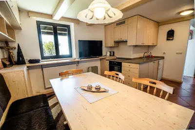 a kitchen and dining room with a wooden table and chairs at Apartments Zvoh, Krvavec, Ski-in, Ski-out in Cerklje na Gorenjskem