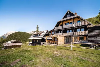 a large wooden house on a hill in the mountains at Apartments Zvoh, Krvavec, Ski-in, Ski-out in Cerklje na Gorenjskem