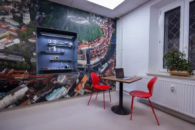 a room with two chairs and a table and a mural at Tiny central studio apartment Nika Ljubljana in Ljubljana