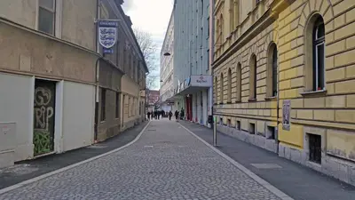 an empty city street with people walking down it at Tiny central studio apartment Nika Ljubljana in Ljubljana