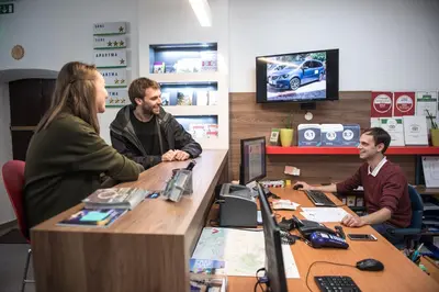 three people sitting at a desk in an office at Tiny central studio apartment Nika Ljubljana in Ljubljana