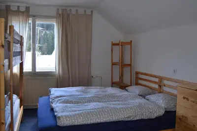 a bedroom with a blue bed with a window at House Cilka in Kranjska Gora