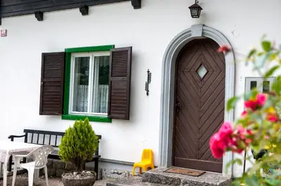 a house with a wooden door and a table and chairs at Sovica in Bled