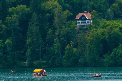 a house on a hill with two boats in the water at Sovica in Bled