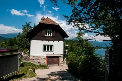 a small white house with a brown roof at Sovica in Bled