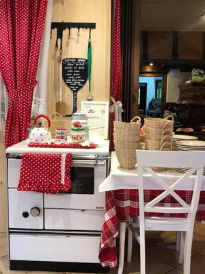 a kitchen with a stove and a table and chairs at Penzion Valerija in Zgornje Jezersko