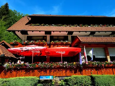 a house with red umbrellas and flowers on it at Penzion Valerija in Zgornje Jezersko