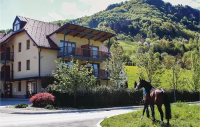 a horse walking in front of a house at Beautiful Apartment In Lasko With Wifi in Laško
